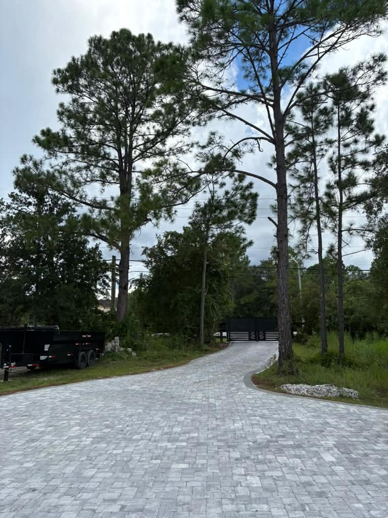 Curving paver driveway leading to gated entry